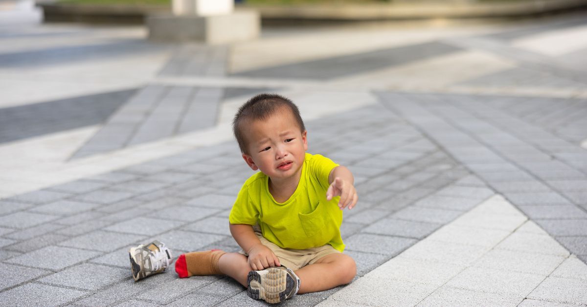 Image of a toddler crying while playing outside 